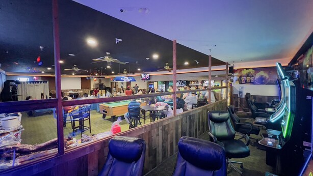 A bar area with pool tables, seating, and a pool table in the foreground. -  Pinckeyville Inn and Suites (Pinckneyville)