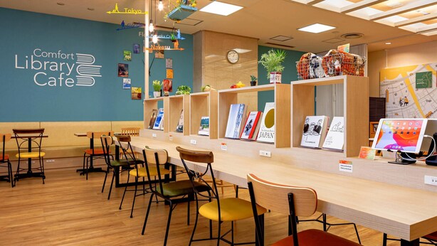 A library cafe with wooden furniture, bookshelves, and hanging plants.