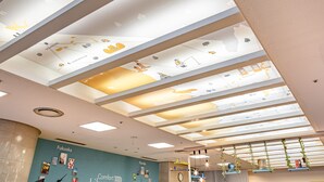 A modern interior with a ceiling featuring a world map and a 'Welcome' sign.