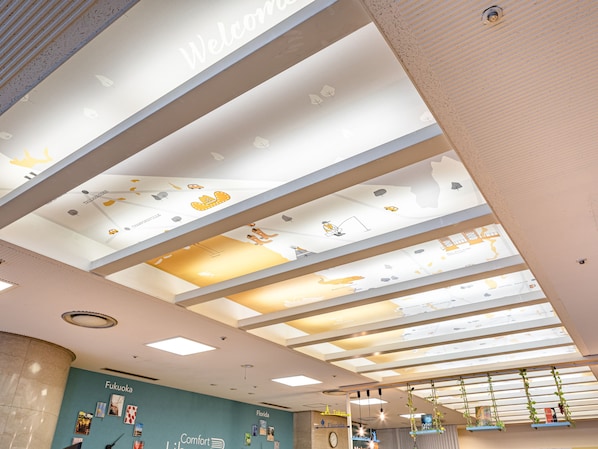 A modern interior with a ceiling featuring a world map and a 'Welcome' sign.