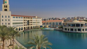A waterfront hotel with a central courtyard, a clock tower, and a pool area. - Millennium Lakeview Residence (Dubai)