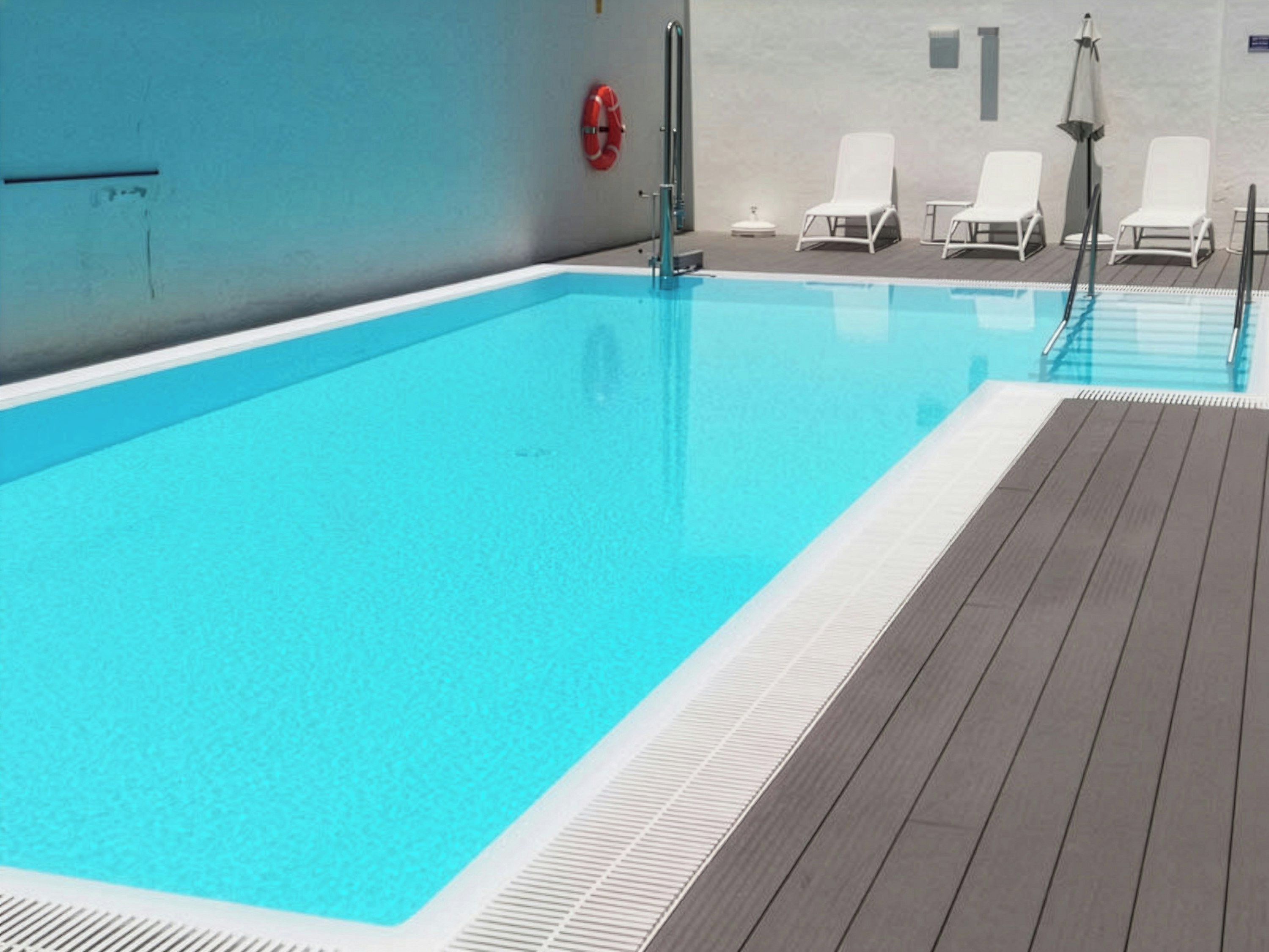 Piscina com deck de madeira, cadeiras de descanso brancas e um boia salva-vidas vermelho.
