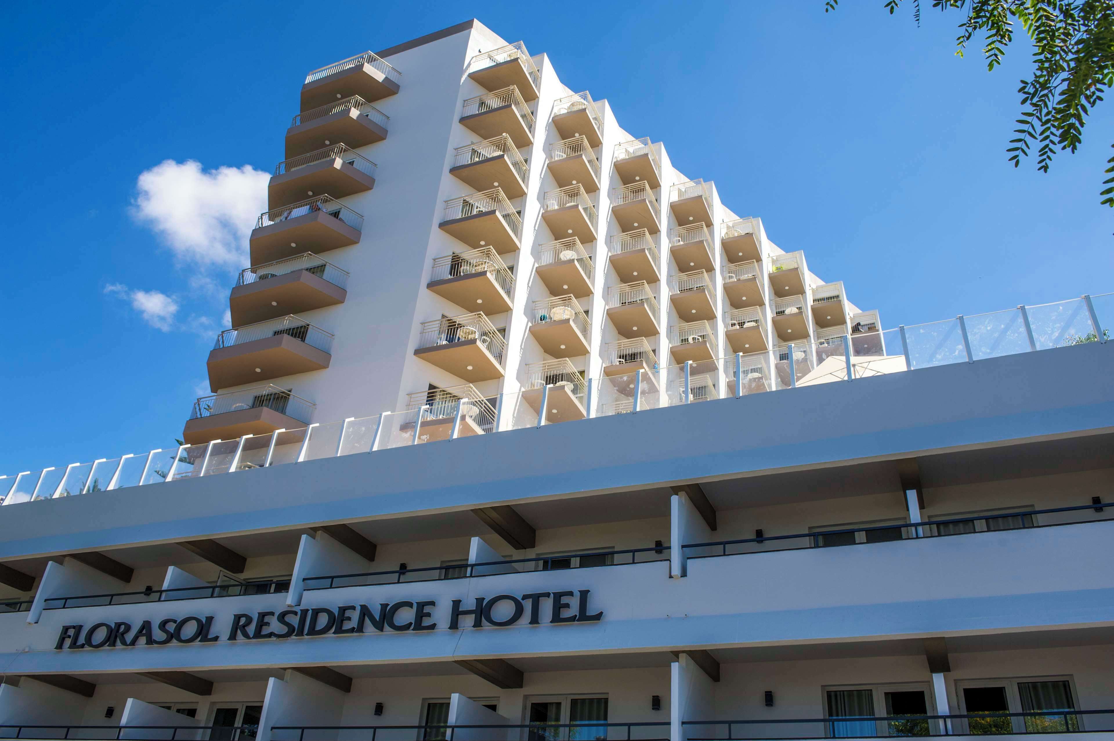 Un hotel moderno con varios balcones y un cielo despejado.