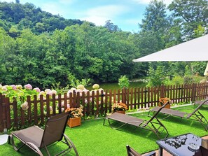 A patio with artificial grass, wooden fence, and outdoor furniture. - Hotel Ciudad Cangas De Onis (Cangas de Onis)