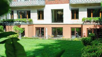 A modern building with a brick facade, large windows, and a well-maintained lawn.