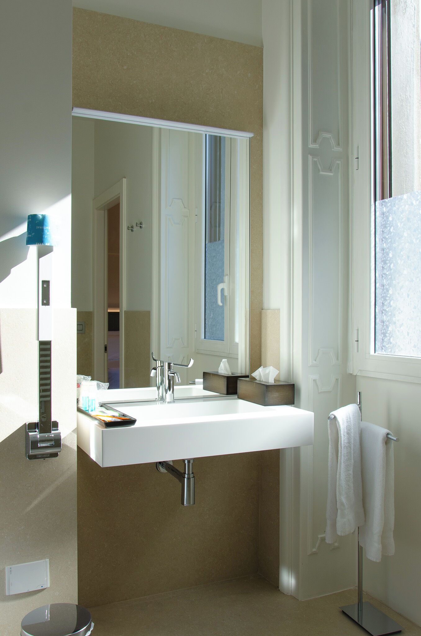 Un baño moderno con un lavamanos grande, un espejo y una ventana.