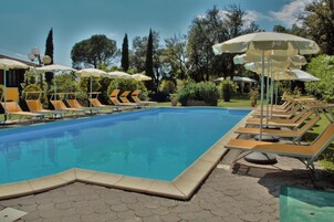 Una piscina al aire libre de temporada, sombrillas