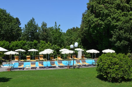 Una piscina al aire libre de temporada, sombrillas