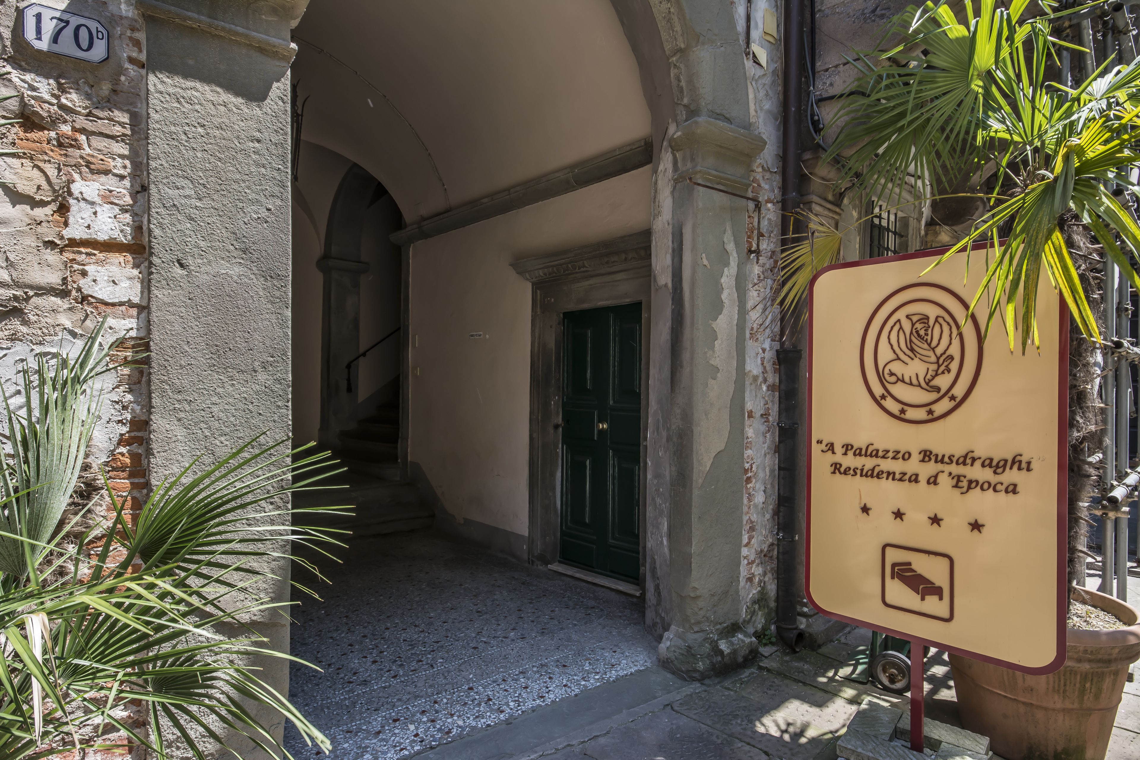 A building entrance with a sign indicating "A Palazzo Busdrach."