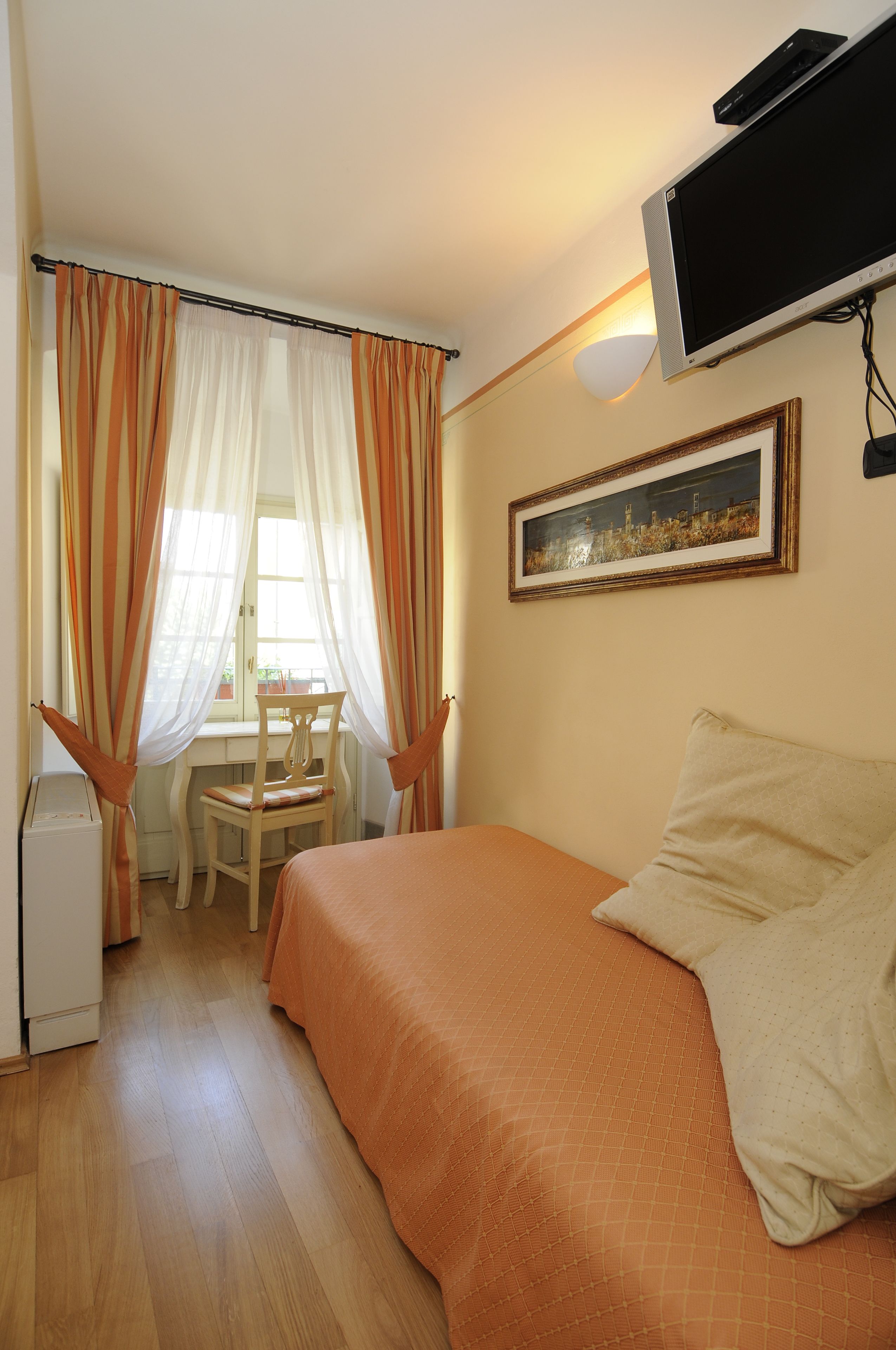 Un dormitorio con cama, escritorio y silla.