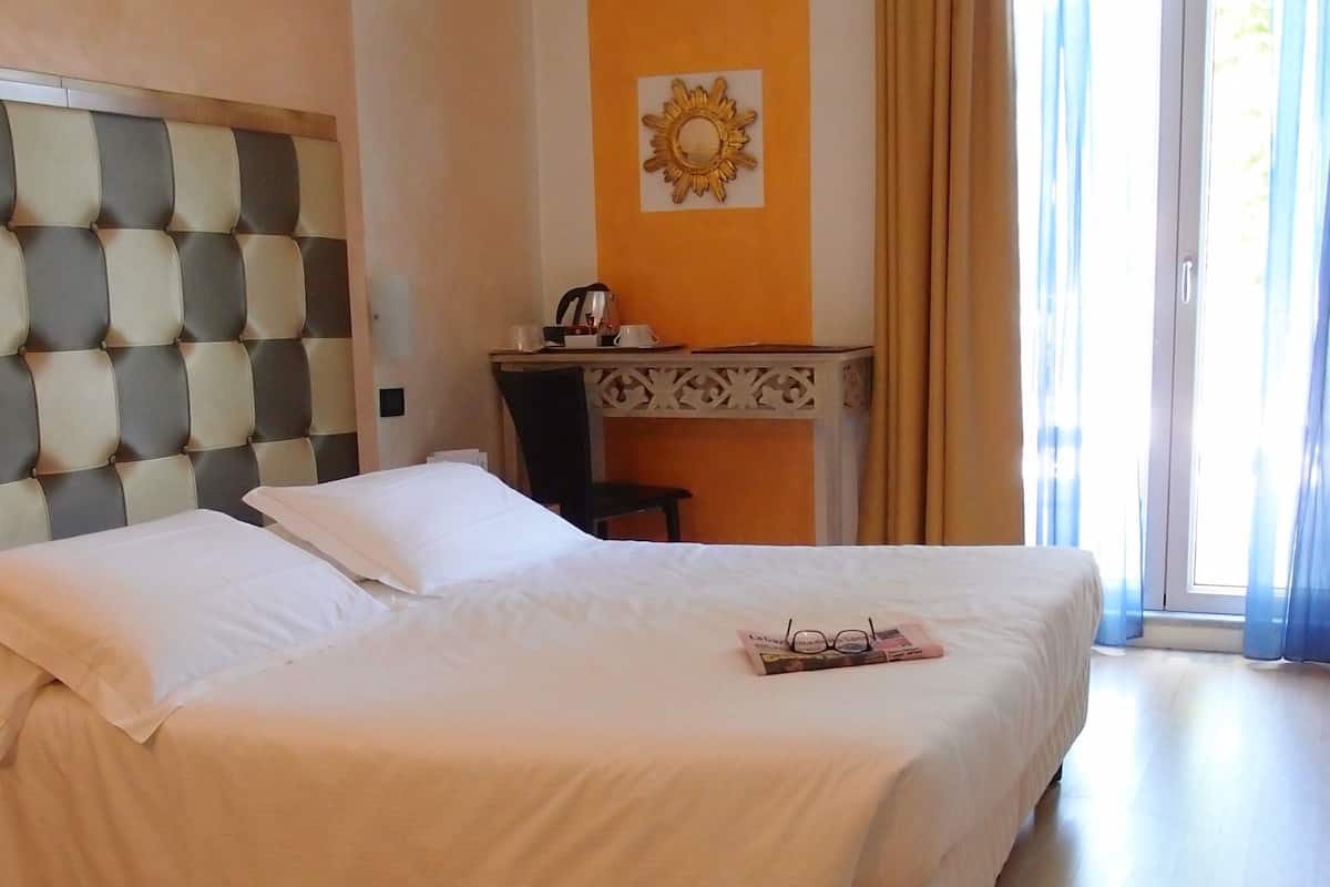 Een hotelkamer met een groot bed, een bureau en een stoel.
