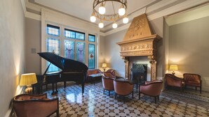 A grand room with a grand piano, a fireplace, and a patterned floor. - Camin Hotel Luino (Luino)
