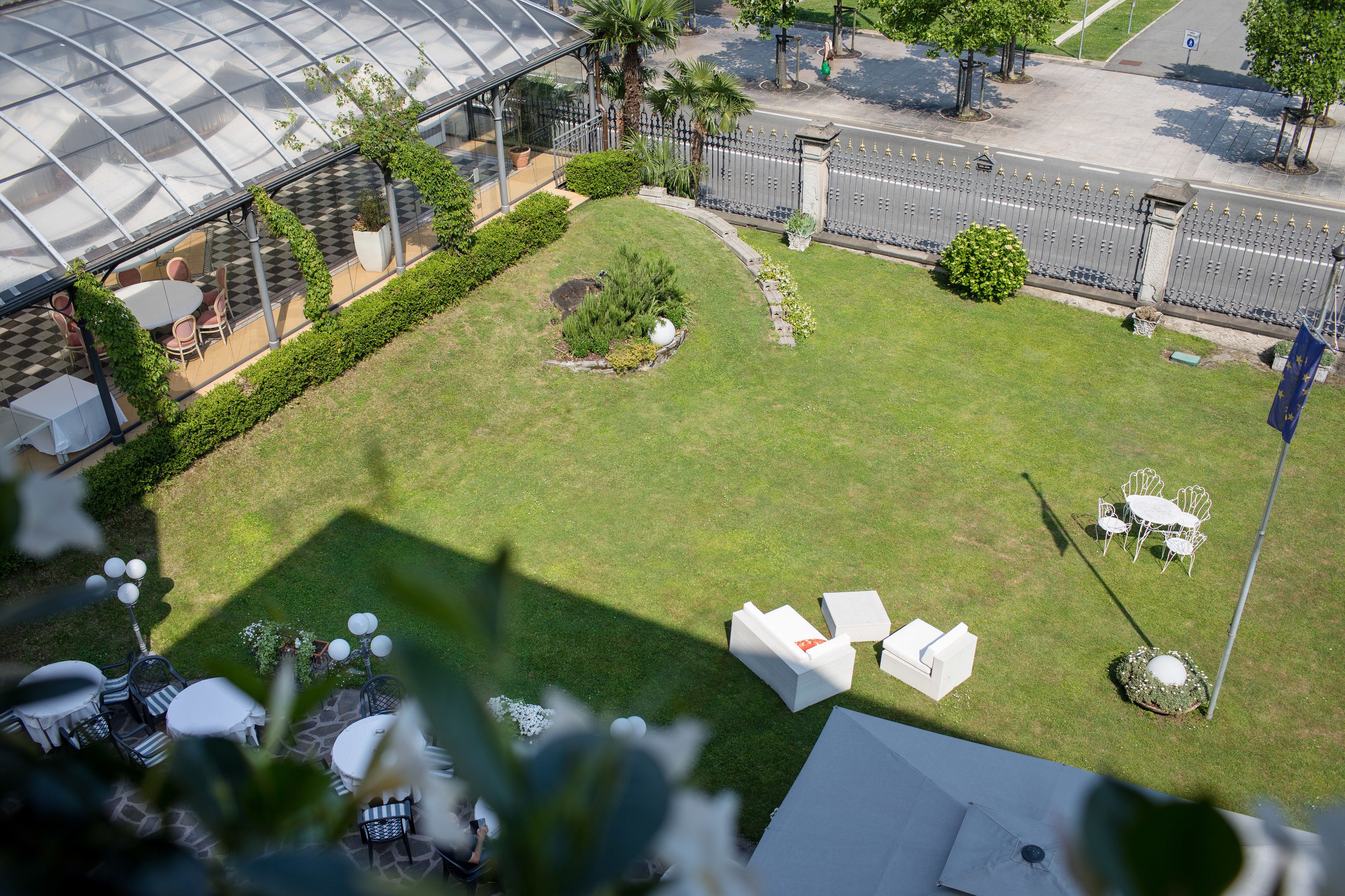 Un jardin sur le toit avec un espace extérieur aménagé pour s’asseoir, une serre et une vue sur la rue.