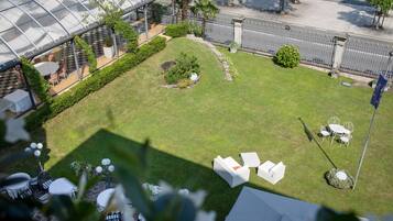 Un jardin sur le toit avec un espace extérieur aménagé pour s’asseoir, une serre et une vue sur la rue.