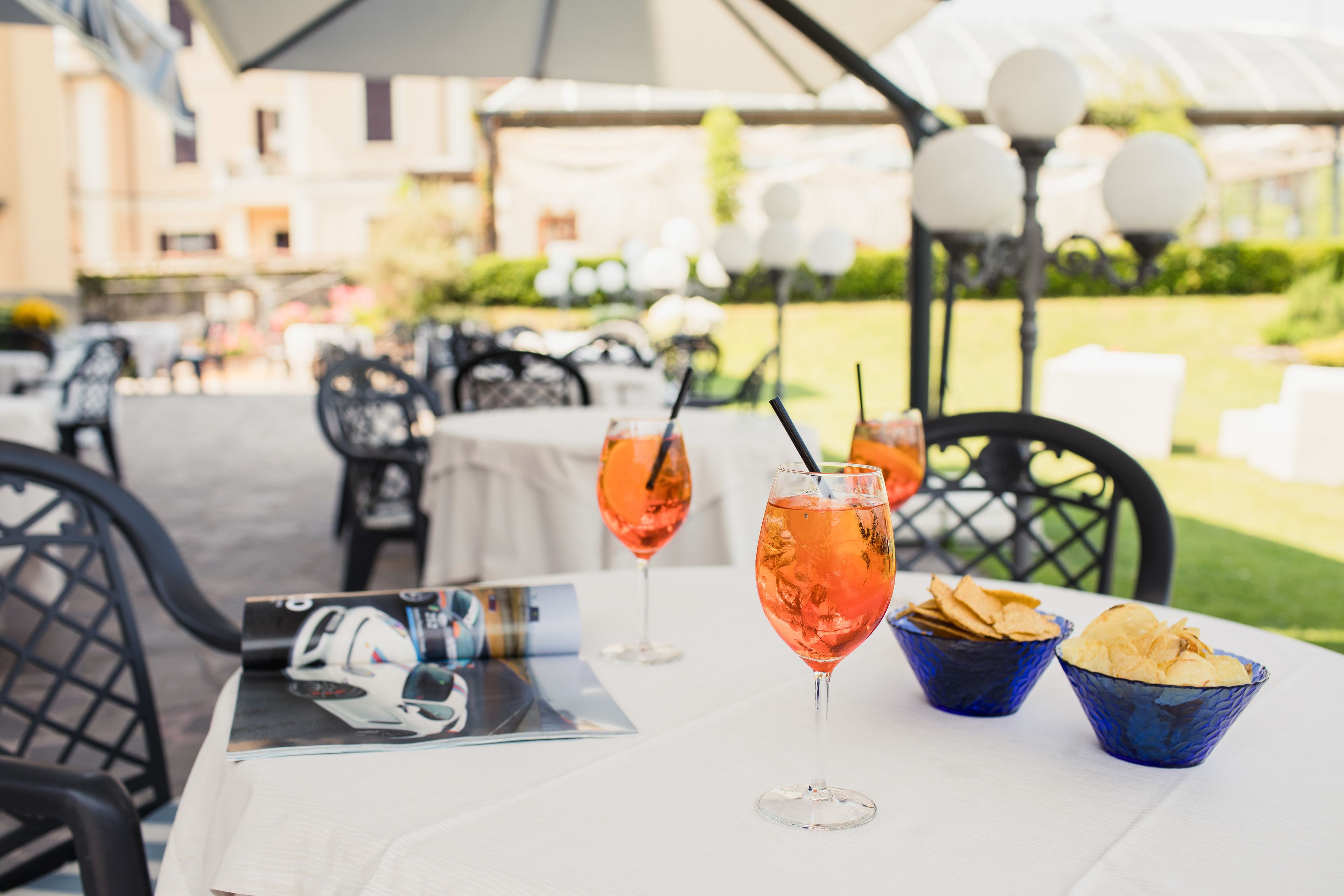 An outdoor dining area with tables, chairs, and drinks.