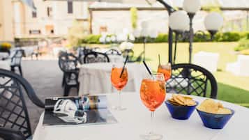 An outdoor dining area with tables, chairs, and drinks.