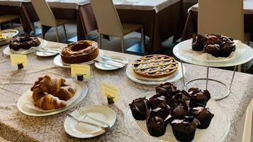 Una mesa de buffet con diversos postres como pasteles y repostería.