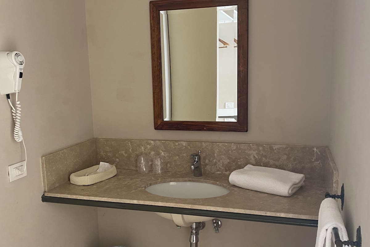 Klassieke Twin kamer | Badkamer | Een bad/douchecombinatie, een haardroger, een bidet, handdoeken