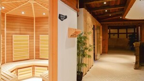 A spa area with wooden benches and a bamboo plant. - Viktoria Eden (Adelboden)