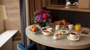 A breakfast table with croissants, fruit, coffee, and juice.