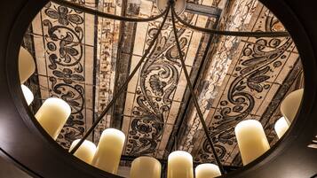 A circular ceiling with ornate tile patterns and a central light fixture.