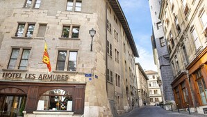 A historic building with a sign reading "HOTEL LES ARMURES".