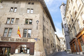 Un bâtiment historique sur lequel on peut lire l’inscription « HÔTEL LES ARMURES ».