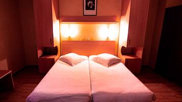A double bed with two nightstands, a headboard with lights, and a framed picture on the wall.