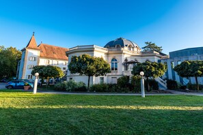 A historic building with a dome and a tower, surrounded by well-maintained lawns and trees. - Grand Hôtel et Centre Thermal (Yverdon-les-Bains)
