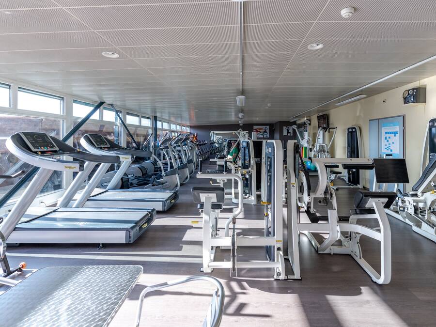 A gym with treadmills, weight machines, and exercise equipment.