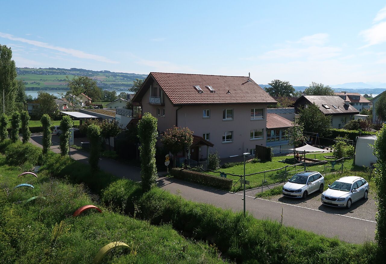 Zona residencial con casas, un estacionamiento y vistas a un lago.