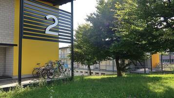 Un bâtiment à la façade jaune, portant le numéro 2. On peut voir des vélos garés devant.