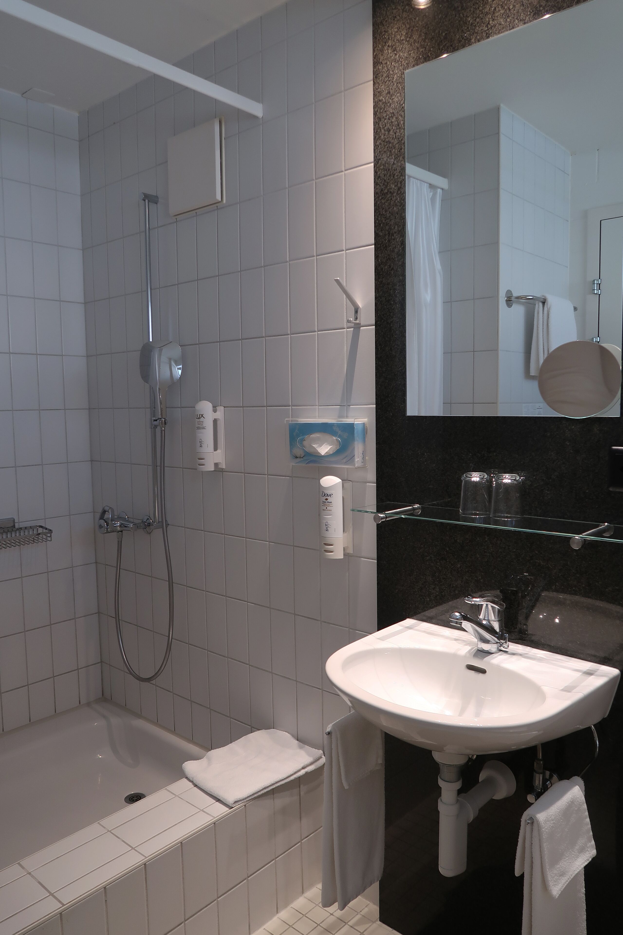 Ein modernes Badezimmer mit Badewanne, Dusche und Waschbecken.
