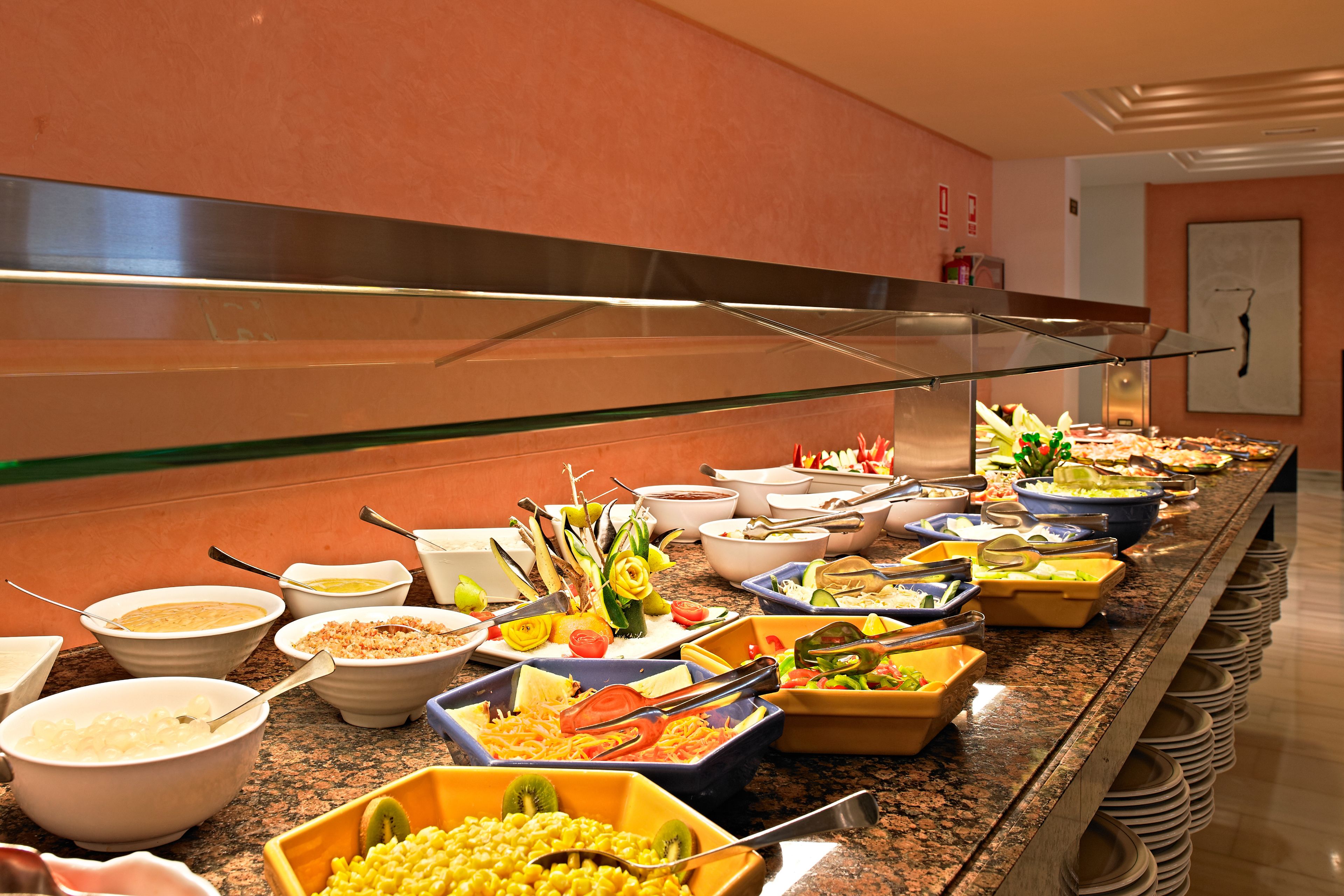 Un buffet proposant une variété de plats et d’ustensiles.