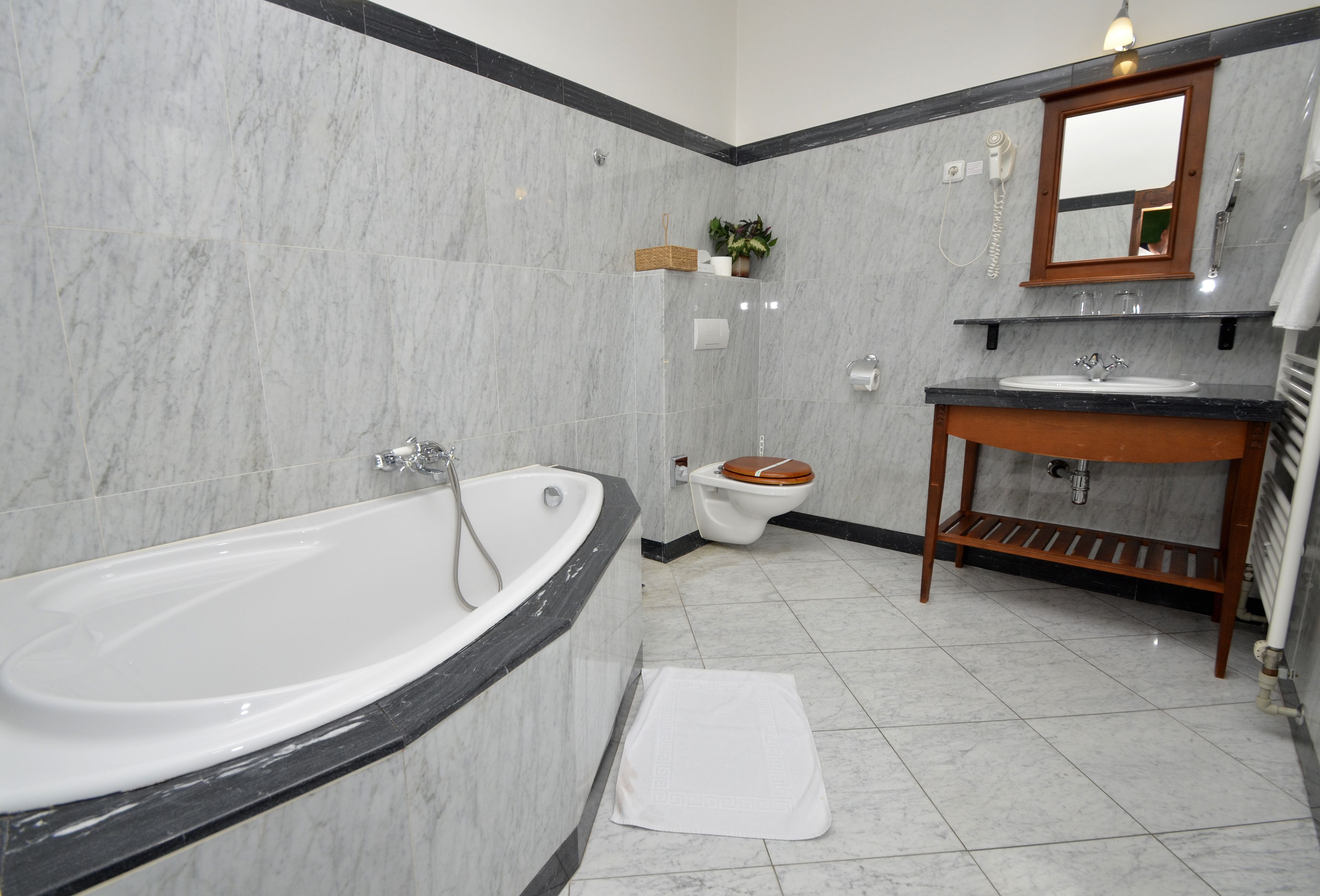 A bathroom with a bathtub, toilet, sink, and mirror.