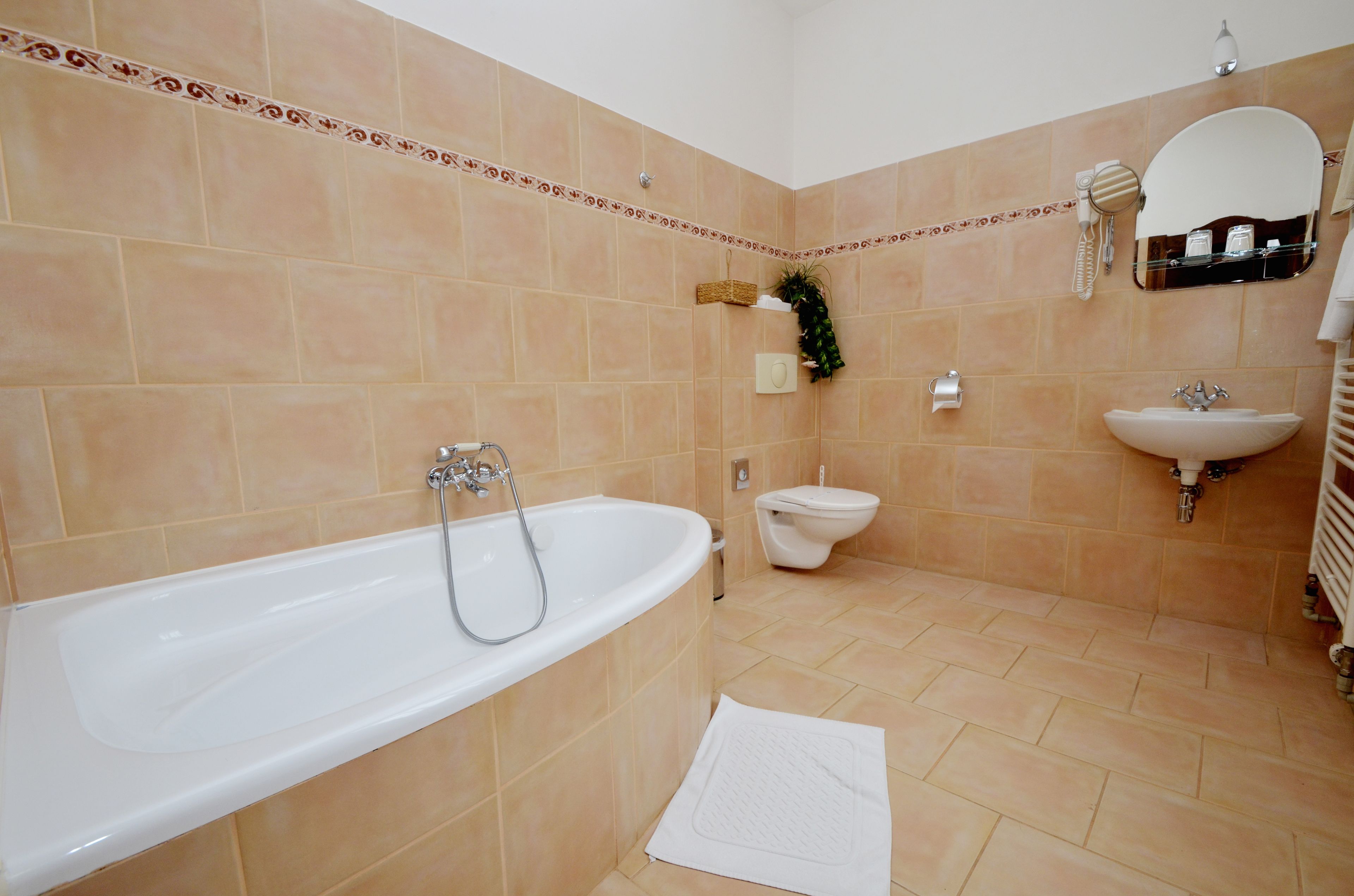 A bathroom with a bathtub, toilet, sink, and a mirror.