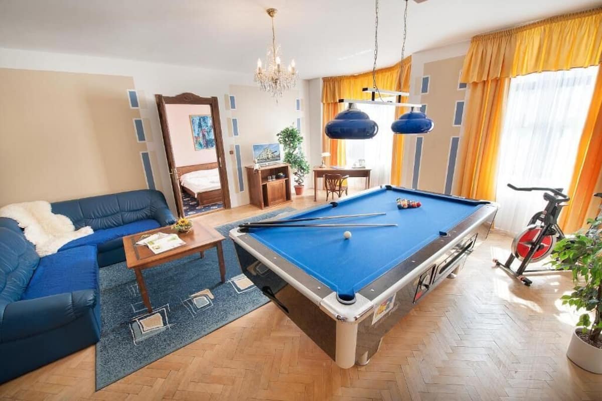 Un salon comprenant une table de billard, un canapé, une table à manger et un vélo.