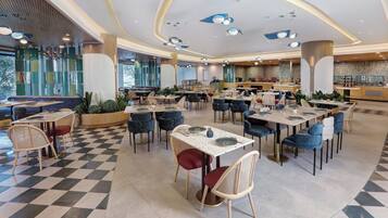 A spacious dining area with checkered flooring, multiple tables, and chairs.