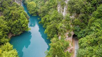 A river winding through a forested gorge with a narrow road alongside.