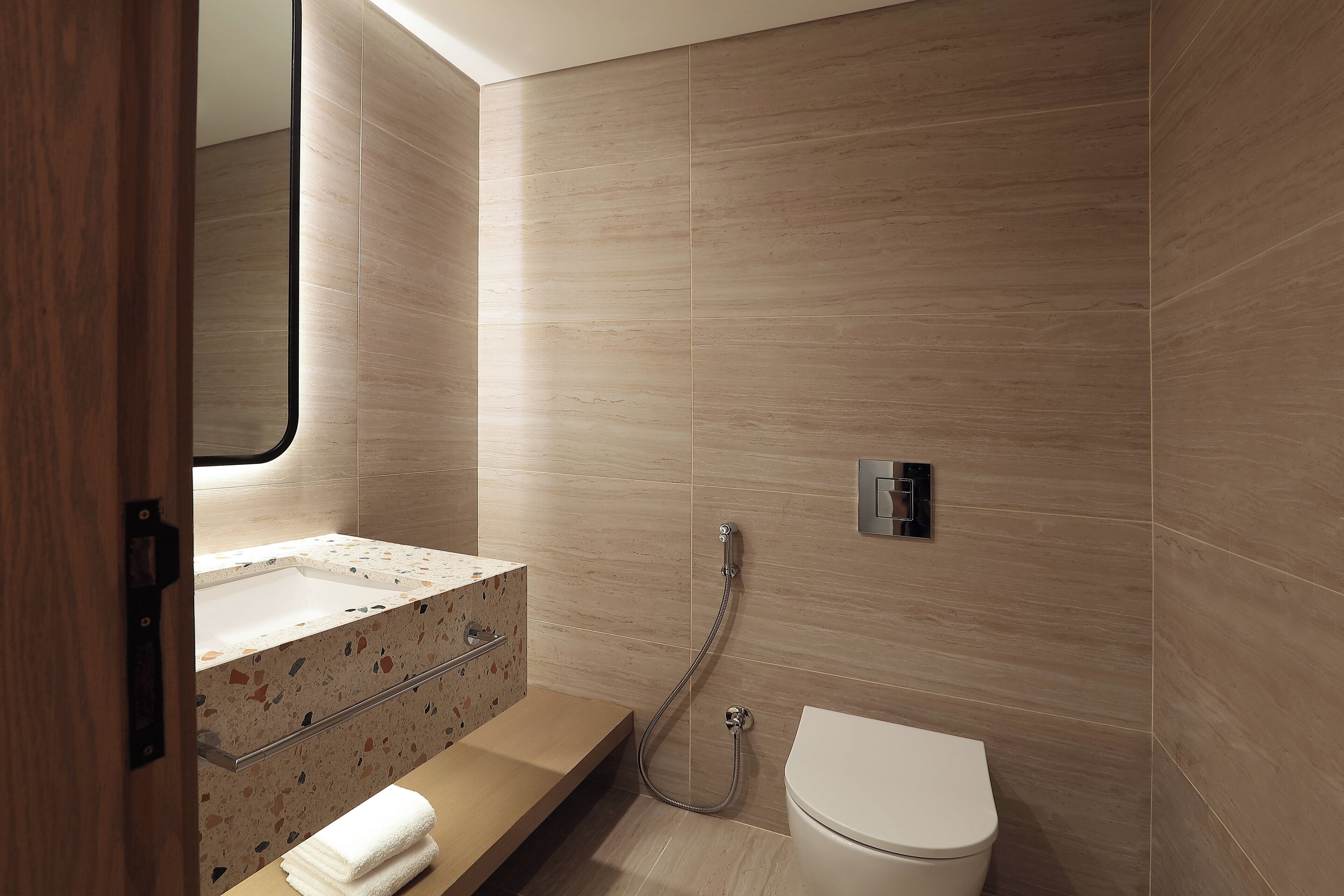A modern bathroom with a freestanding bathtub, a toilet, and a vanity with a mirror.