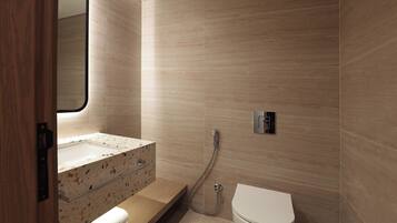 A modern bathroom with a freestanding bathtub, a toilet, and a vanity with a mirror.