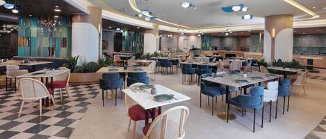 A spacious restaurant with multiple dining areas, modern lighting, and a checkered floor pattern.