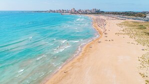 A beach with clear turquoise waters, a sandy shore, and a city skyline in the background. - voco Beirut Central District by IHG (Beirut)