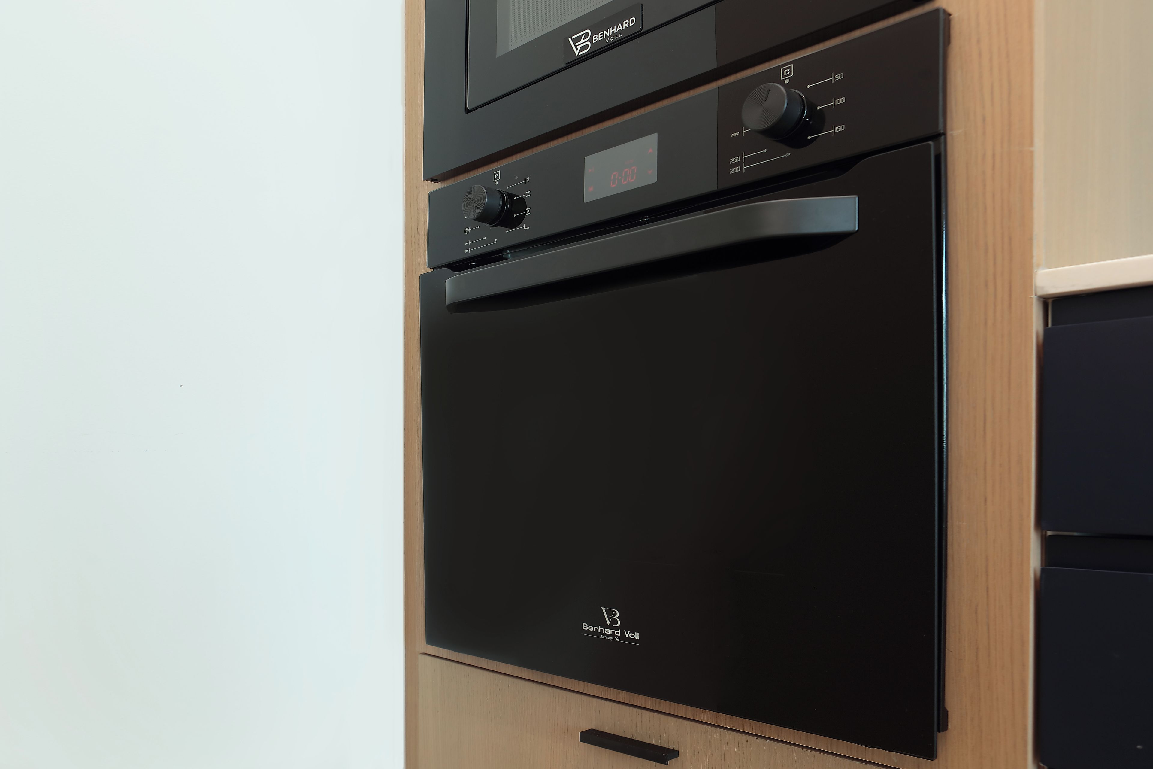 A black Benhard Voll oven with a digital display and control knobs.