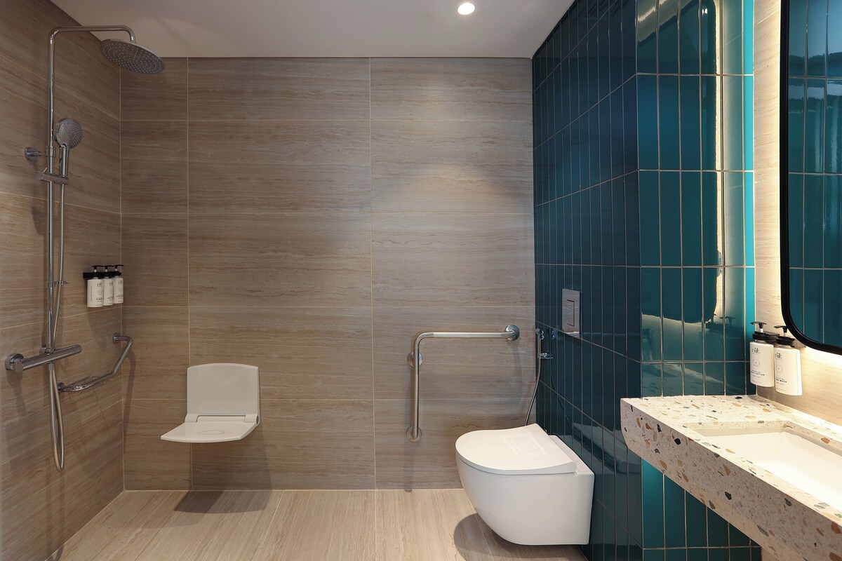 A modern bathroom with a shower, toilet, and sink.