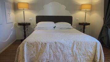 A neatly made bed with a white bedspread and two bedside lamps.