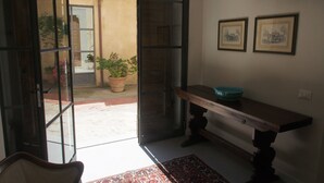 An interior space with a wooden bench, a potted plant, and two framed pictures on the wall. - I Parigi Corbinelli (Florence)