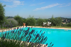 Una piscina al aire libre, tumbonas