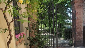 A garden with potted plants and a wrought iron gate. - I Parigi Corbinelli (Florence)