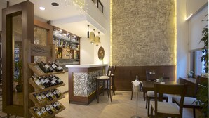 A bar area with wine racks, seating, and a decorative wall with a map pattern. - Barin Hotel (Istanbul)